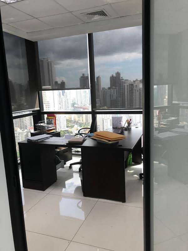 Private office interior with L-shaped desk and large window with city skyline at PH Tower Financial Center Panama