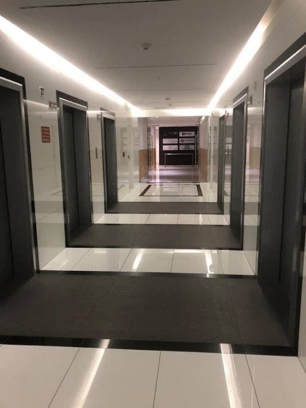 Modern elevator lobby area with multiple elevators, tile flooring, and accent walls inside PH Tower Financial Center Panama