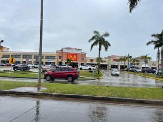 Spacious living room with neutral tile flooring and white walls in family house Monte Limar