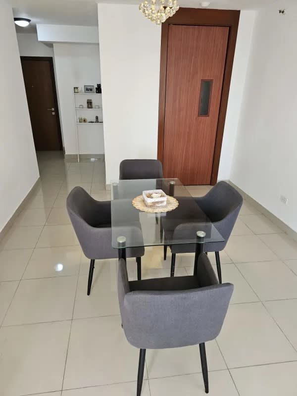 Elegant dining area with glass table, upholstered chairs Residencias del Sol Panama City
