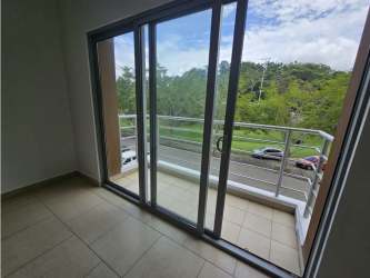 View from covered balcony overlooking green trees PH Soleo Panama Pacifico