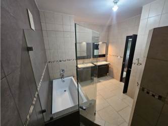 Contemporary bathroom with double sink, glass shower enclosure, modern tile in PH Soleo Panama Pacifico