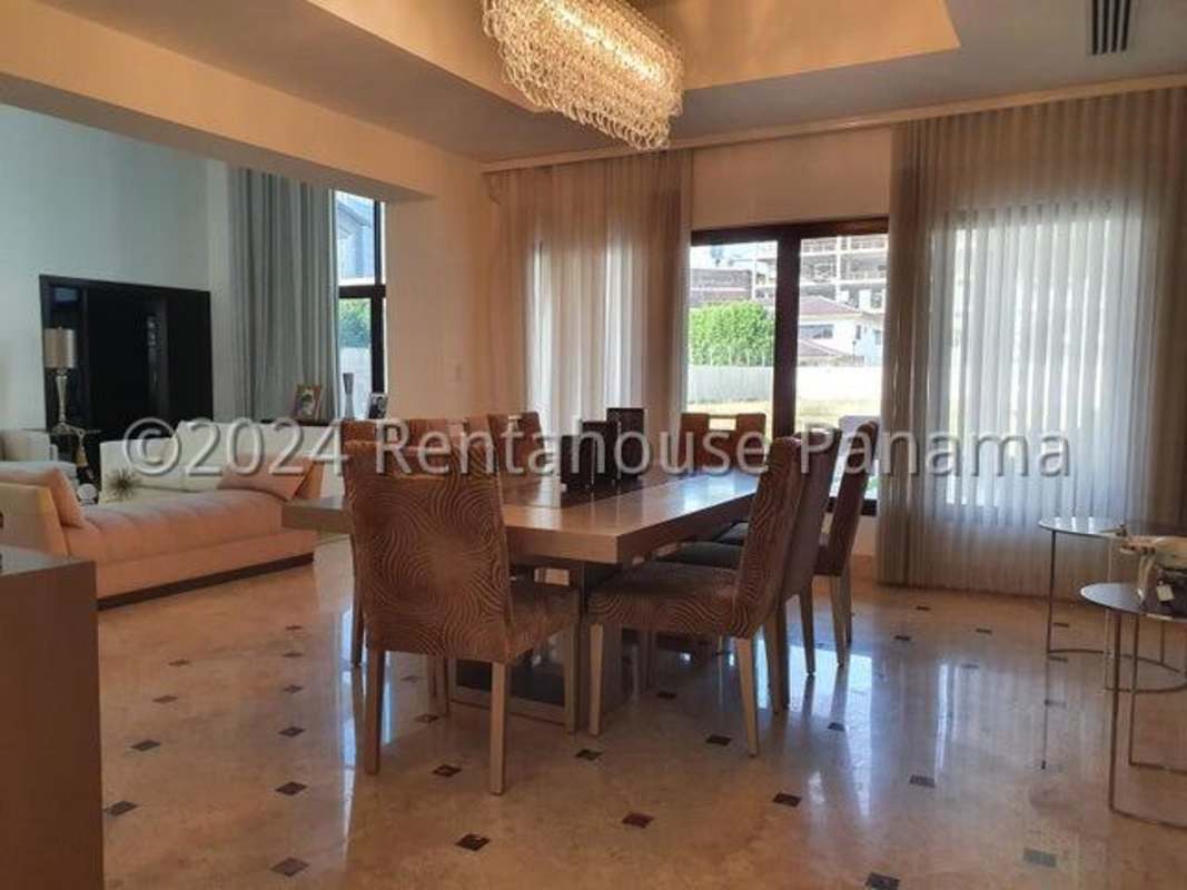 Luxury kitchen with granite counters, island, white cabinets, hanging light fixtures in Costa del Este