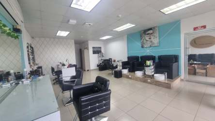 Modern minimalist treatment room with two massage tables tiled wall and cabinetry in spa rental Panama Oeste