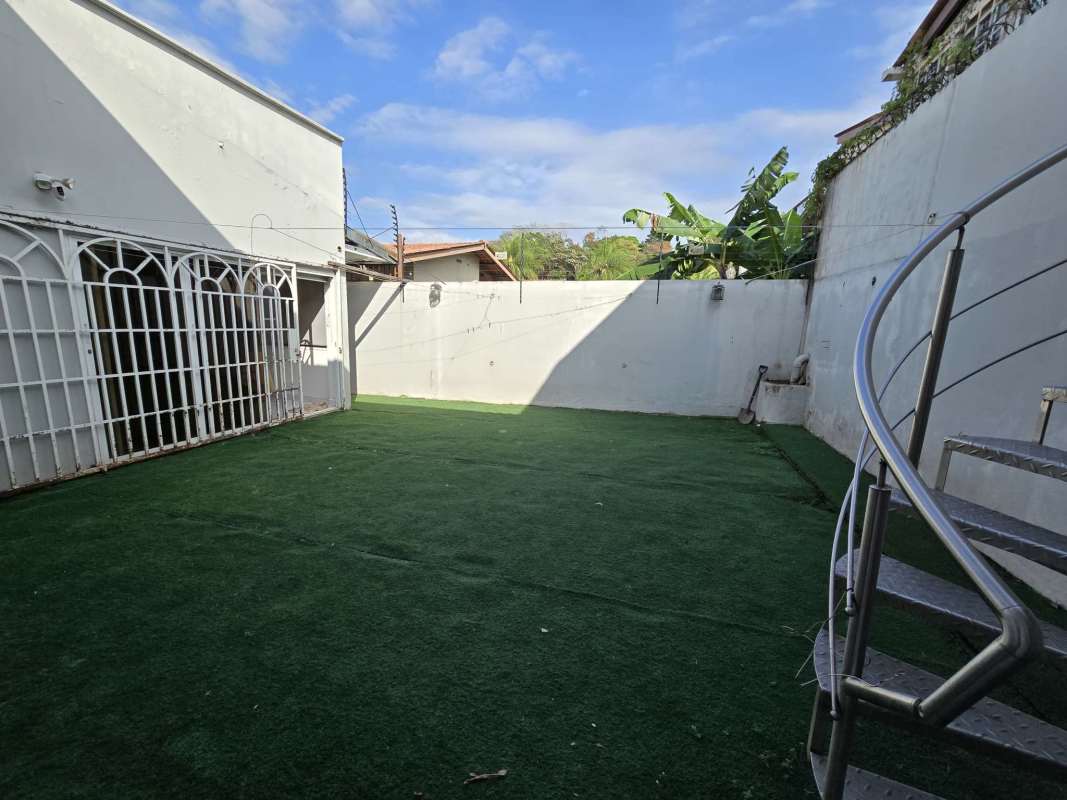 Spacious backyard with artificial turf, secure wall and spiral staircase in Brisas del Golf Panama