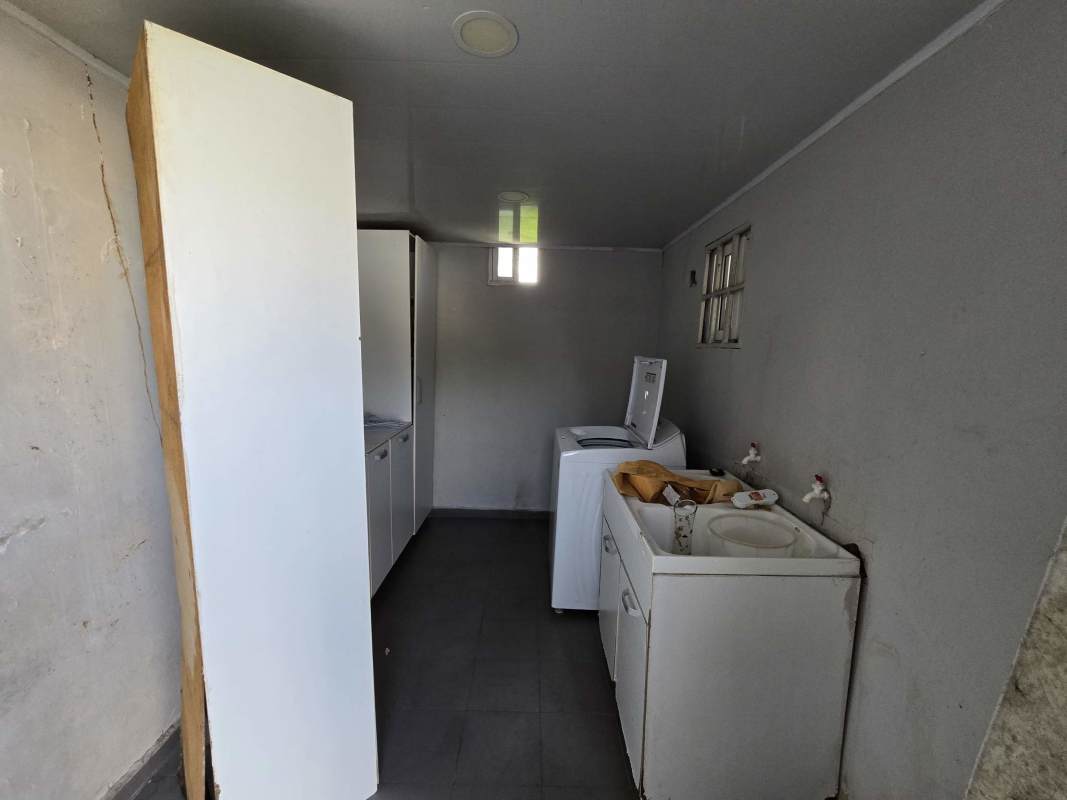 Simple laundry room with washer, storage cabinets, window, in Brisas del Golf house Panama