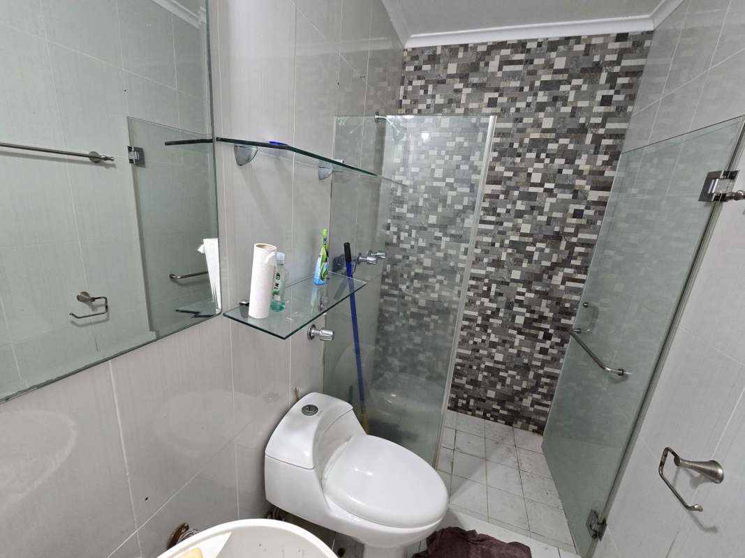 Stylish bathroom with walk-in shower, glass enclosure, mosaic tile wall in Brisas del Golf Panama