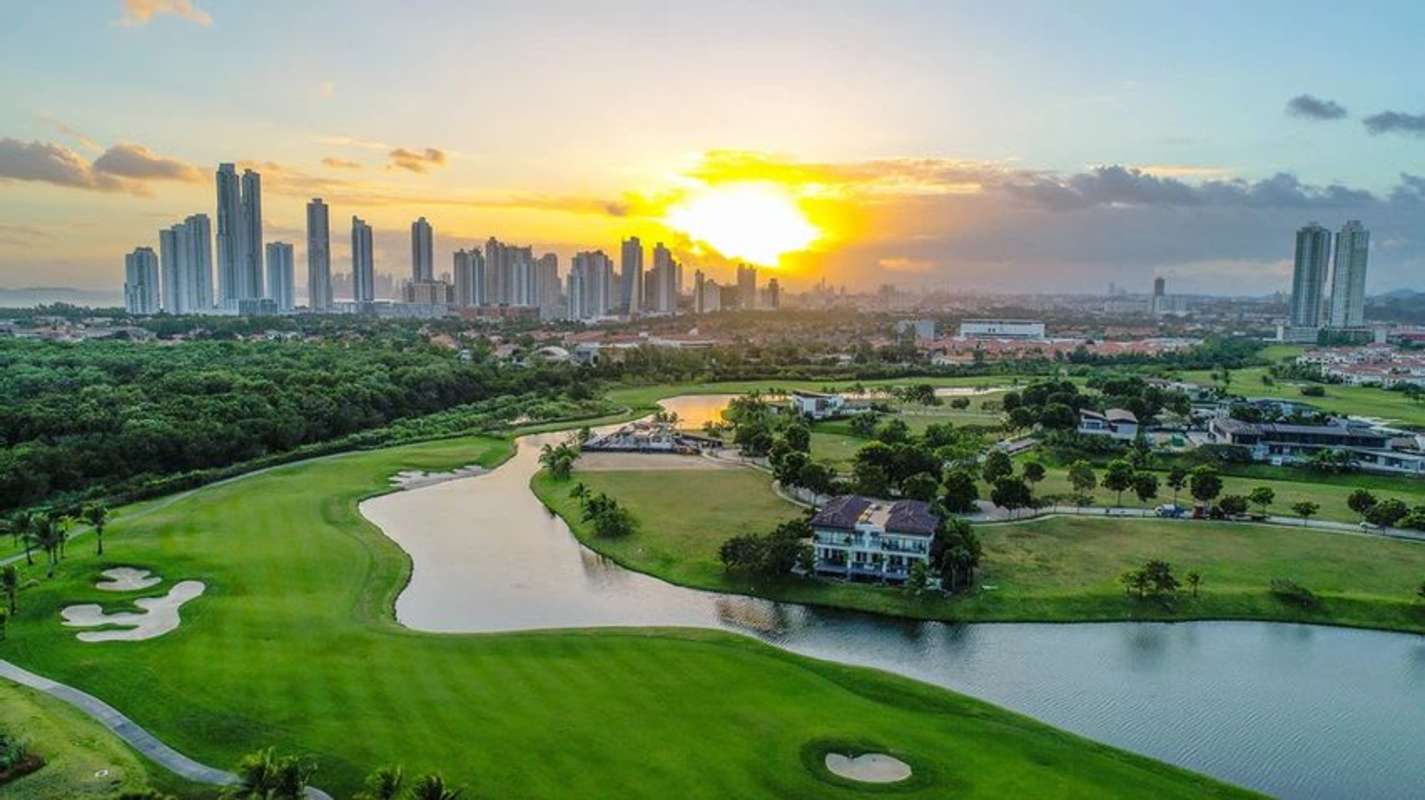 Luxury apartments surrounding golf course with water features aerial view at sunset in Santa Maria Costa del Este Panama