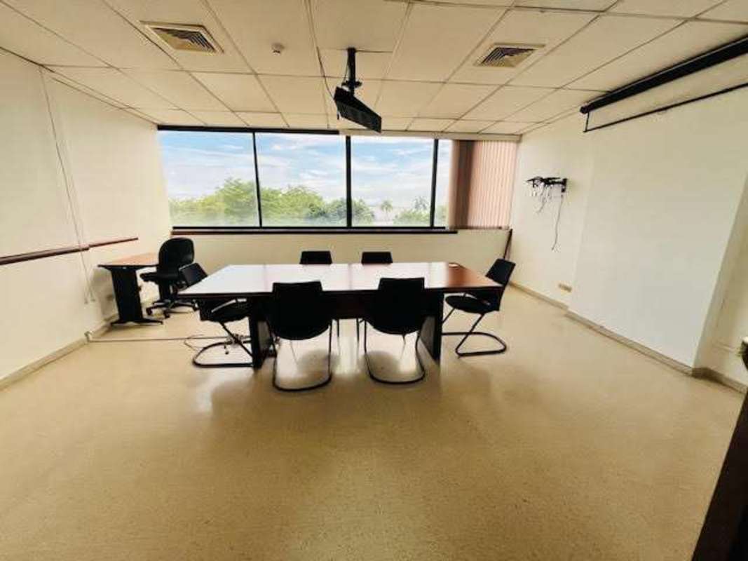Enclosed private office room with large windows facing the ocean and city skyline