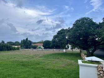Mediterranean style entrance with red tile roof, columns, landscaped gardens at Hacienda Pacifica San Carlos
