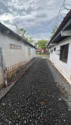 Single-story white building with gravel lot and utility installations in Costa Verde Barrio Balboa Panama