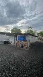 Open outdoor gravel yard with utility buildings and parking in Costa Verde Barrio Balboa Panama