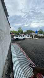 Gravel parking lot with vehicle access beside warehouse in Costa Verde Barrio Balboa Panama