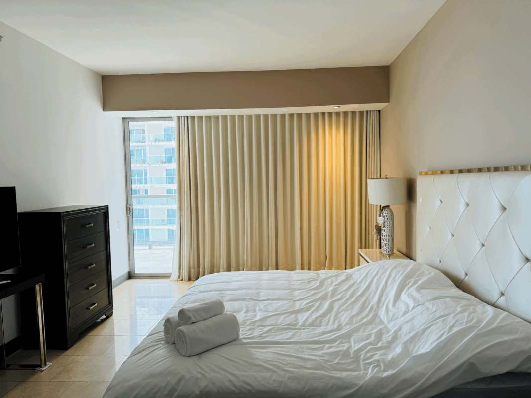 Luxurious bedroom with large windows and city skyline views PH The Ocean Club Punta Pacifica