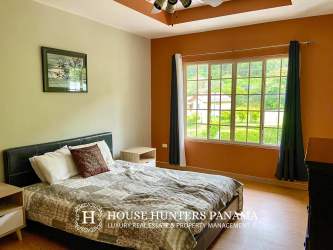 Bright bedroom with ceiling fan, accent wall and garden view in PH Valle del Río Boquete