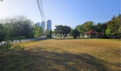 Open lawn lot with small pavilion and mature trees under blue sky Rio Mar