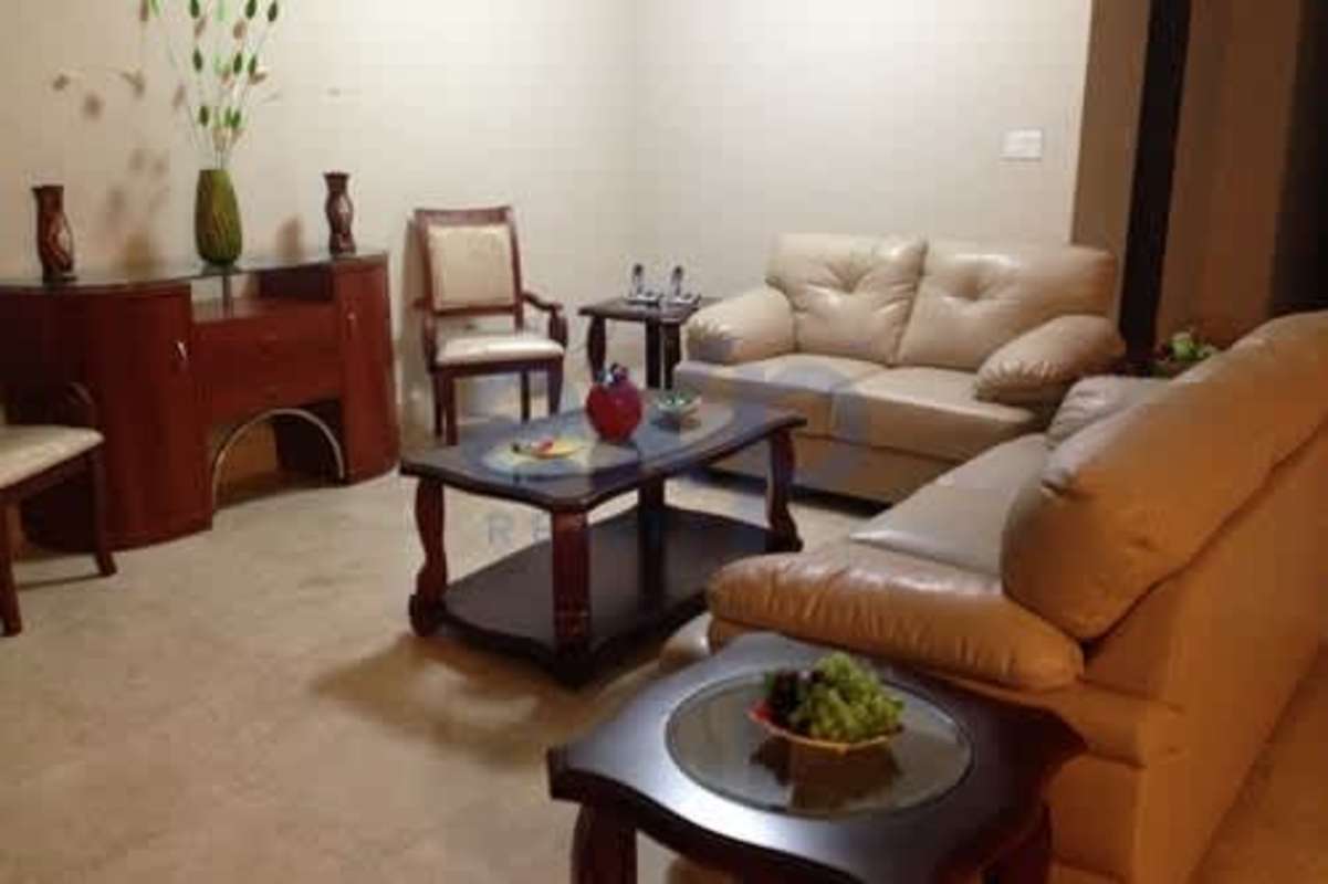 Spacious living room with beige leather sofas and wooden tables in PH Terrazas del Pacífico luxury apartment Panama