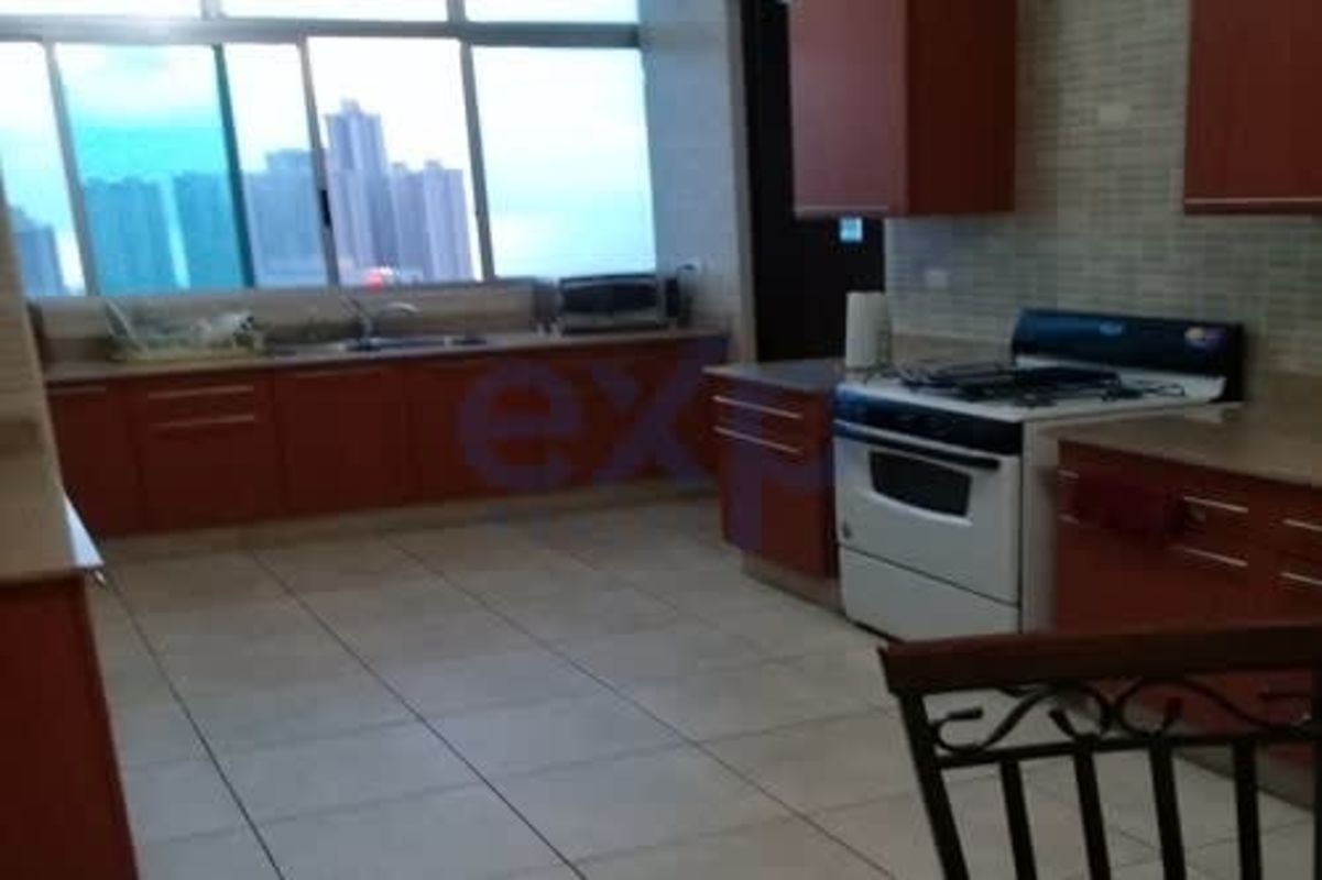 Large kitchen with wood cabinetry and city skyline window in PH Terrazas del Pacífico Panama