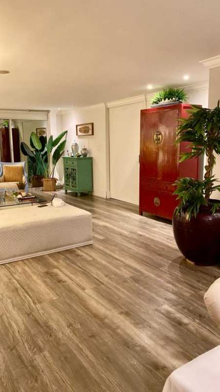 Elegant entryway with mirror, table, lamp and wood flooring in La Alameda Villa de las Fuentes