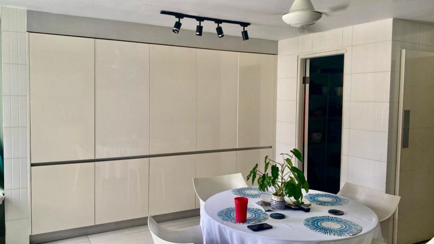 Bedroom with large windows, bed, striped chair and ceiling beams Villa de las Fuentes Panama City