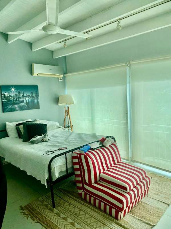 Bedroom with windows, white bed, art, open shelving and desk Villa de las Fuentes Panama