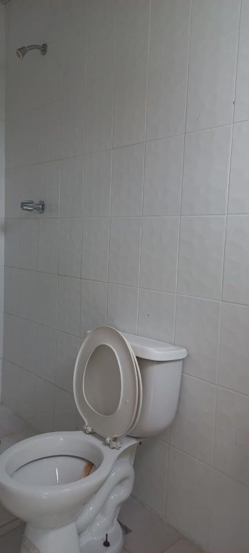 Minimalist bathroom with tiled walls, white ceramic fixtures, shower PH Ámbar Pedregal in Panama City