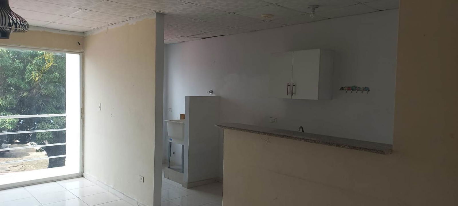 Minimalist kitchen with granite countertops and balcony sliding door in PH Ámbar Pedregal Panama City