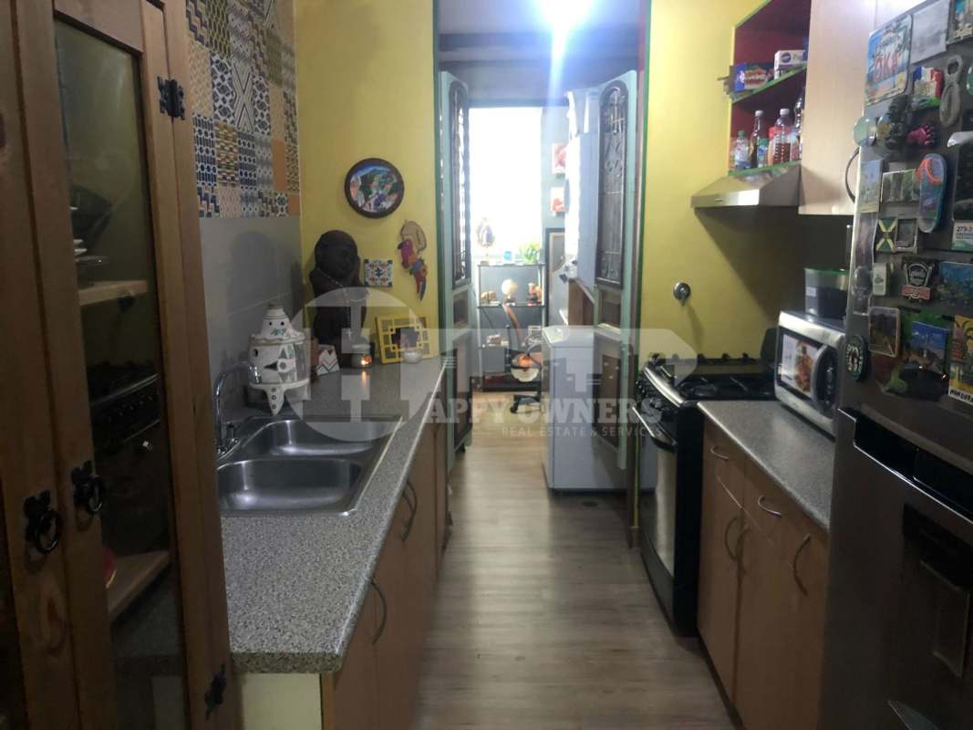 Galley style kitchen with wood cabinets, gas stove, refrigerator in PH Central Park