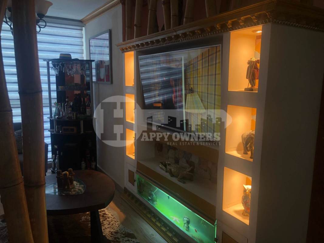 Living room with aquarium, illuminated shelves, flat-screen TV and mini bar in PH Central Park Panama
