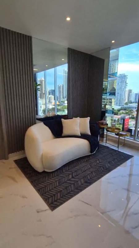 Curved white sofa set beside large corner windows with skyline views at PH Amazonas Bella Vista Panama City