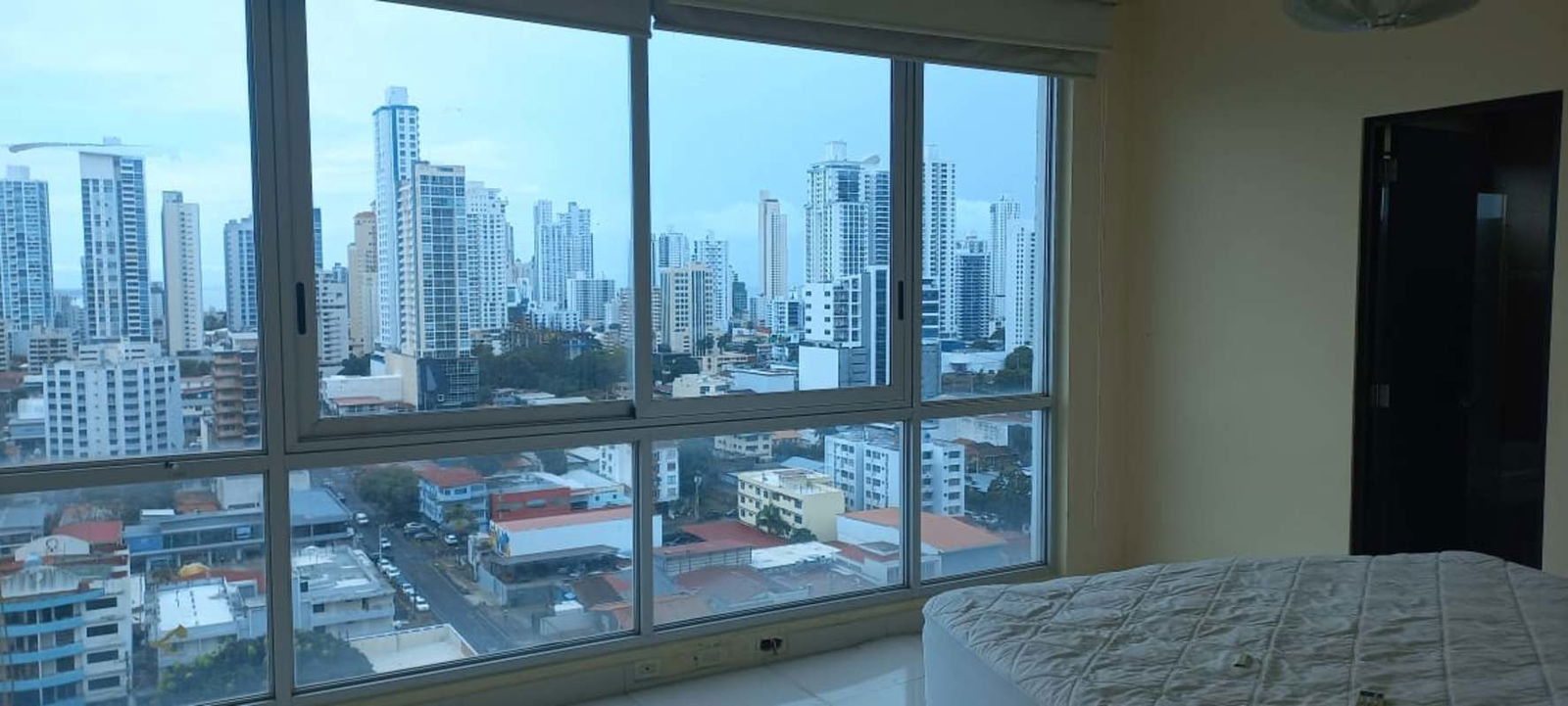 Bedroom with large windows overlooking skyline in PH Keops Tower San Francisco Panama