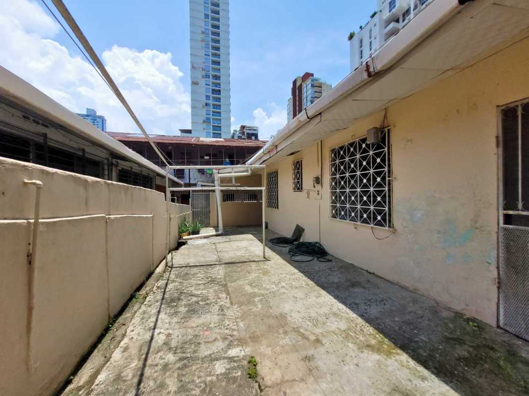 Secured backyard patio utility area with cement flooring and garden wall in San Francisco Panama investment property