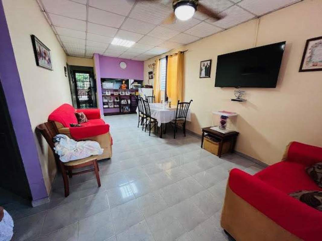 Open living and dining area with furniture and wall-mounted TV house San Fernando Panama