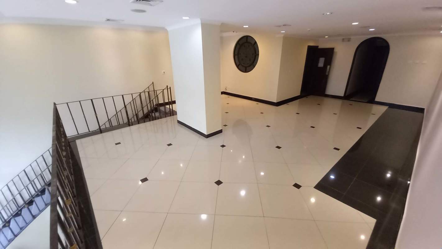 Commercial interior hallway with tile floors, staircase, pillar and circular window in Panama City