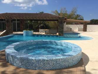 Covered terrace with views of tropical gardens and swimming pool at Punta Barco Village Panama