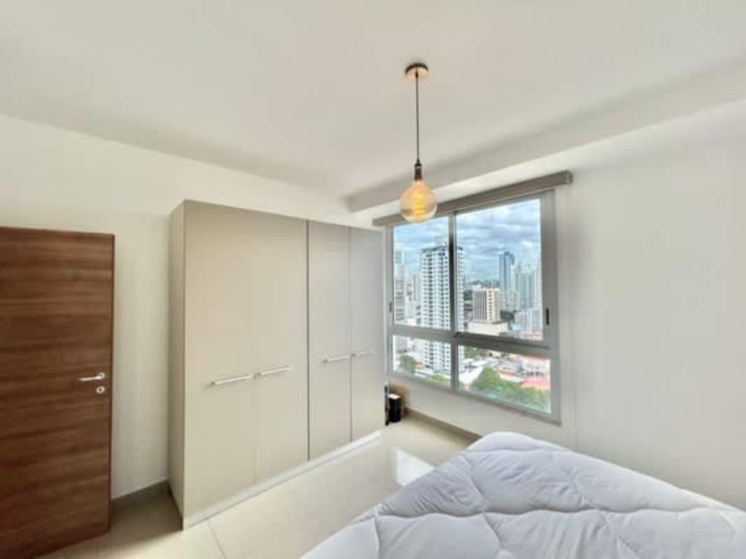 Modern bedroom with large windows and a panoramic skyline view, built-in wardrobe in PH Great City Panama