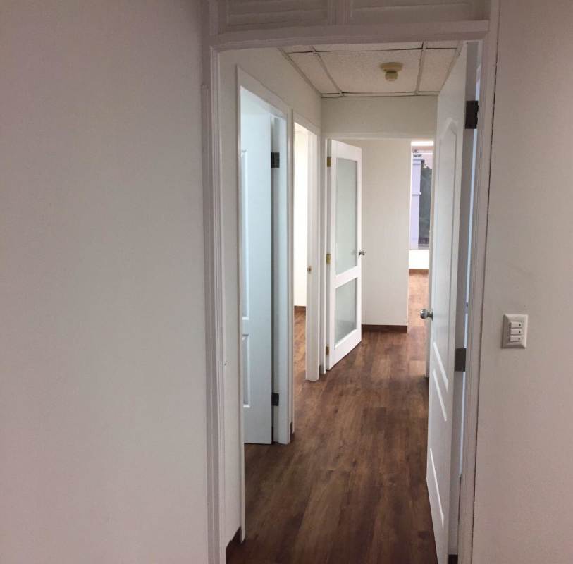 Office corridor with glass door entry, wood floor at Plaza Ejecutiva Panama City