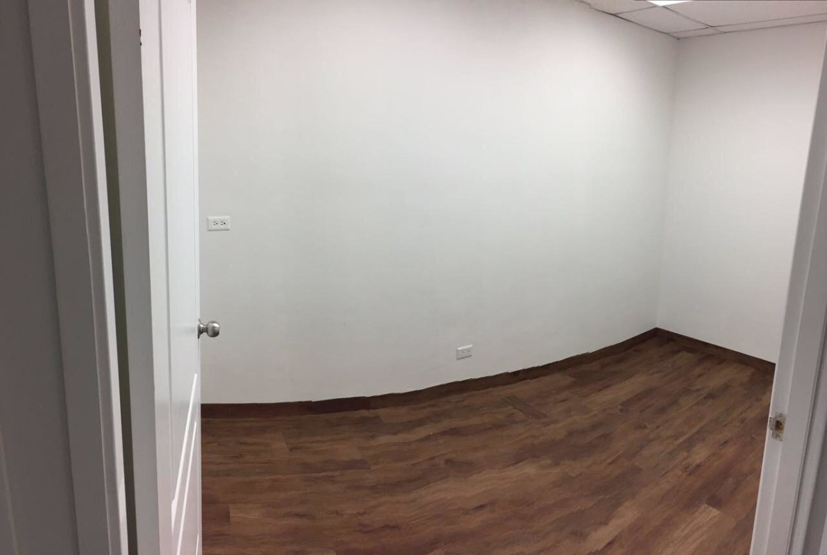 Modern private office with white walls, wood floors, large window Obarrio Panama
