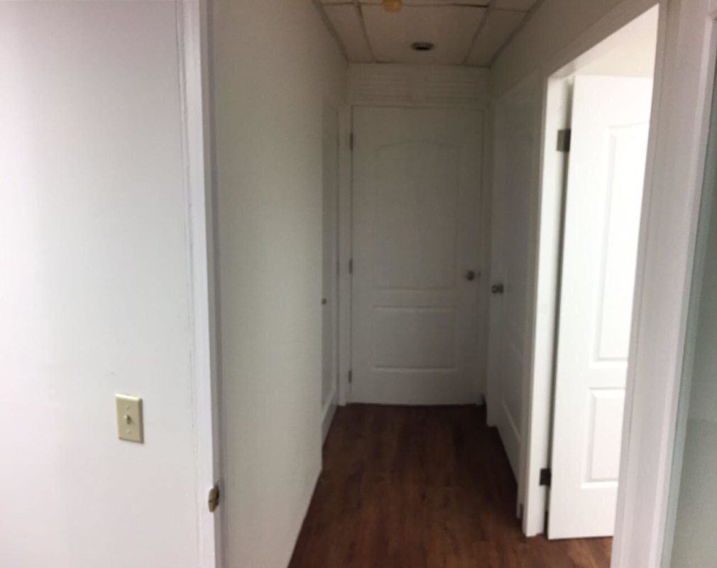 Interior hallway with multiple doors, wood floors, modern lighting in Plaza Ejecutiva Obarrio Panama