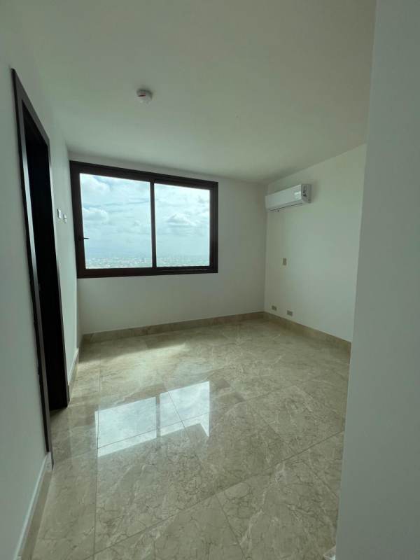 Spacious modern bedroom with large window, marble floors and city skyline view at The Colonial Santa Maria Panama
