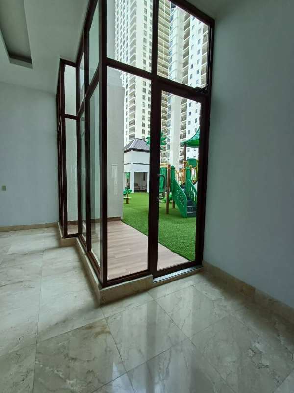 Wide hallways with glass doors and marble floors overlooking playground in The Colonial Santa Maria Panama