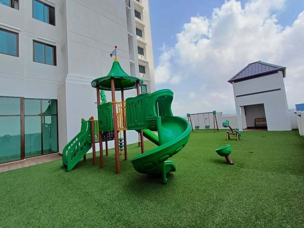 Rooftop kids playground with swings, slides, artificial grass at The Colonial Santa Maria Panama