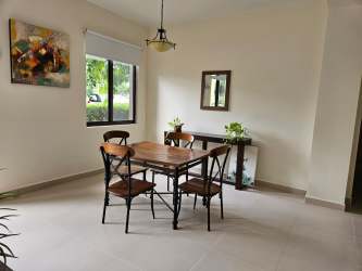 Modern dining area with large window, wooden table and mirror River Valley Panama Pacifico