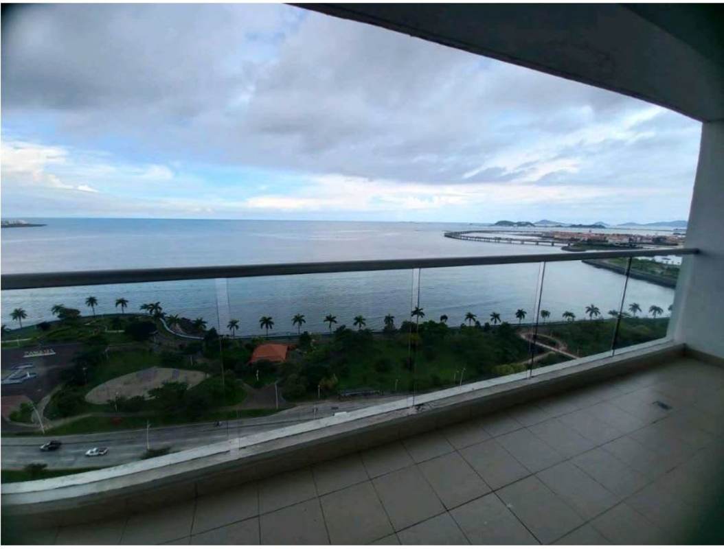 Bright unfurnished living room with tile floors, large glass doors opening to ocean view balcony in PH Rivage Panama