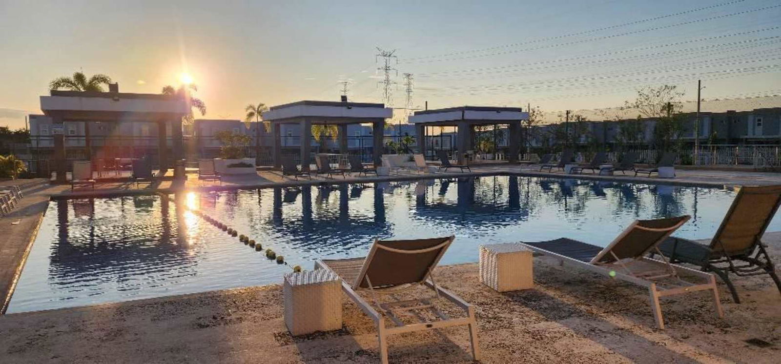 Large outdoor residents swimming pool with cabanas and lounge chairs at PH Augusta & PH Alpes Brisas del Golf Panama City for rent