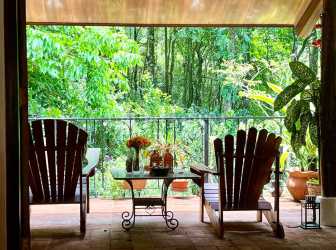 Covered deck with Adirondack chairs overlooking forest in Panama