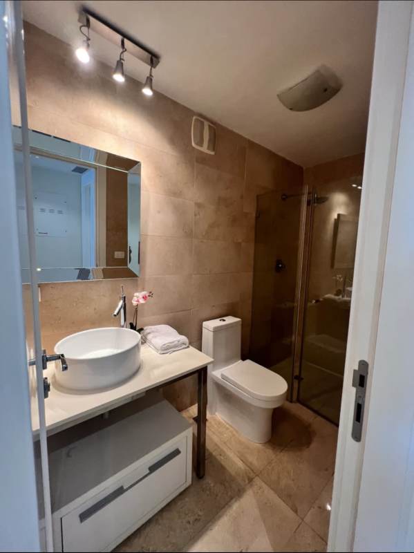 Modern bathroom with glass enclosure and vessel sink in Yoo Panama Tower