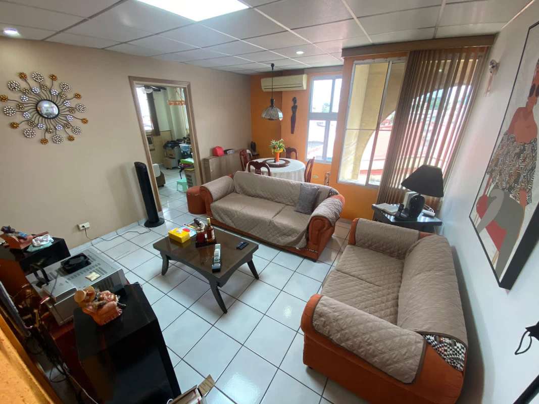 Living and dining space with sofa, round table, split AC, tiled floor Panama apartment