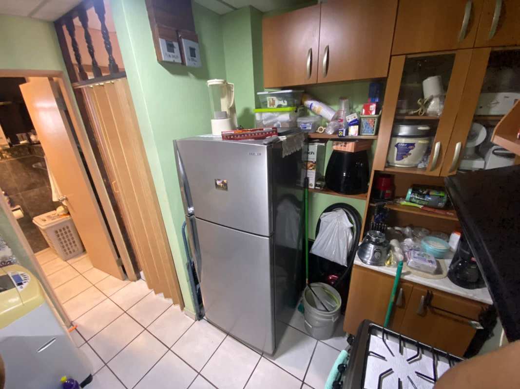 Efficient kitchen space with silver fridge cabinetry appliances in affordable Rio Abajo apartment