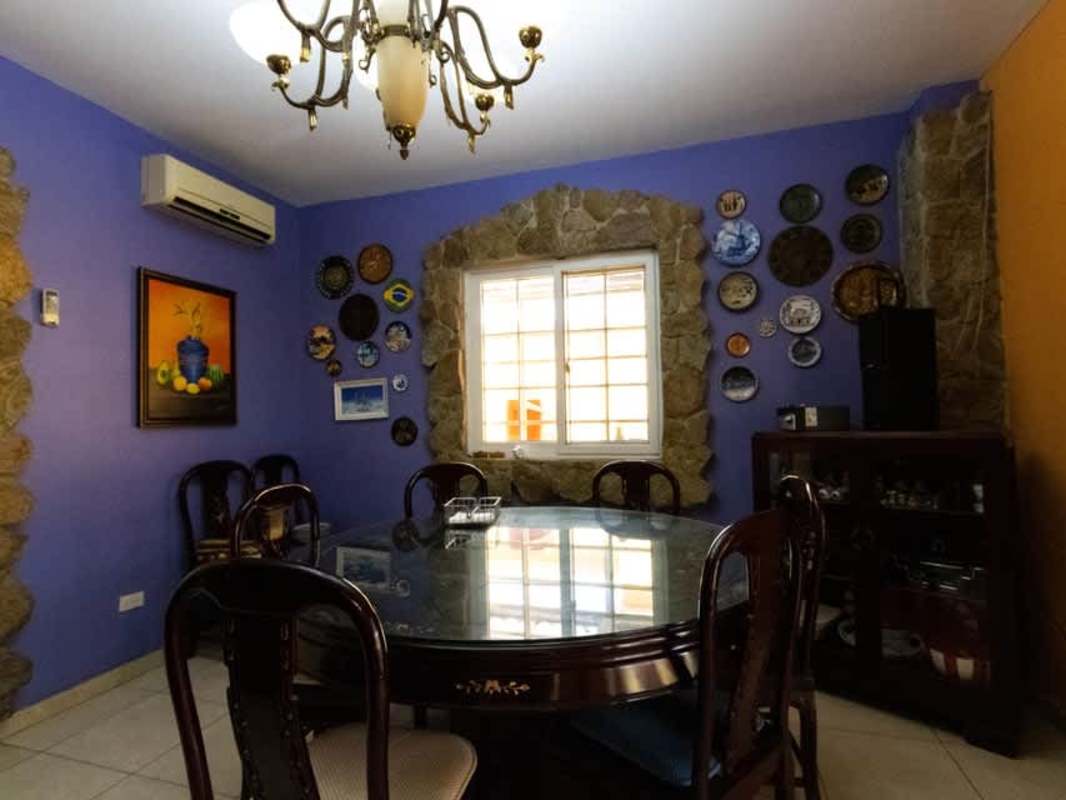 Dining area with stone framed window, chandelier, blue accents PH Rainforest Villas Panama City